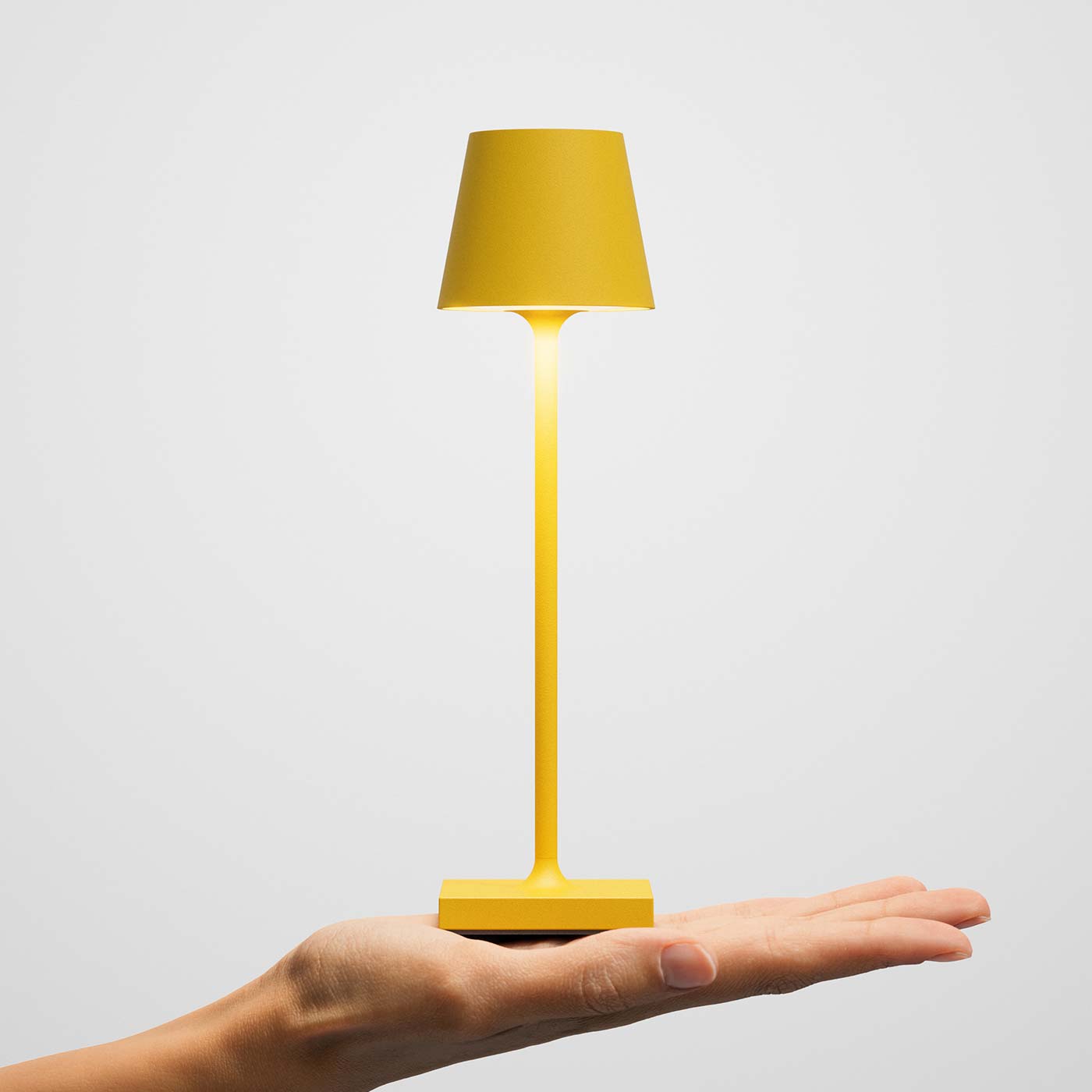 Sigor Nuindie pocket, lampe sans fil, rechargeable en jaune sur la main